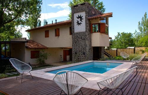 波特雷里约斯Las Espuelas Casas de Montaña的一座带椅子和时钟的游泳池的房子