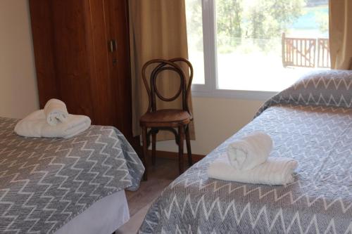 佩休尼亚镇El Arrayan的卧室配有床、椅子和窗户。