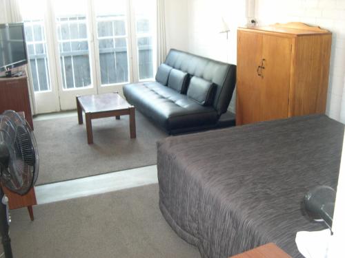陶朗加Strand Motel的客房设有床、沙发和桌子。