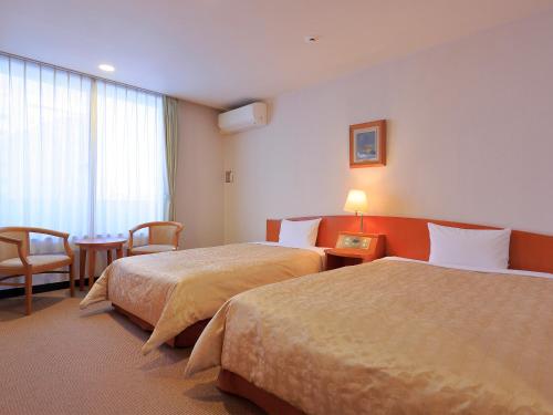 横滨ESCALE-YOKOHAMA的酒店客房设有两张床和一张桌子。