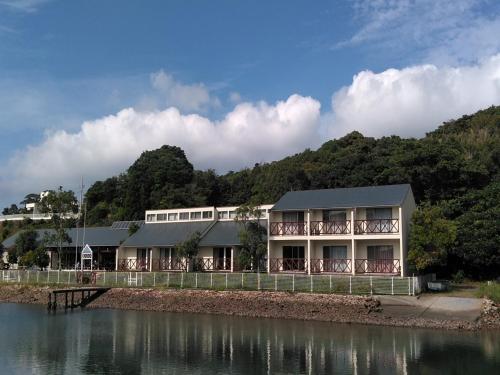 志摩市Tabist Villa Daio Resort Ise-Shima的水体旁边的建筑物