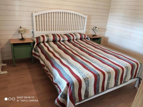 TorrellesCasa Ecoeficiente Eguzkilore的卧室内的一张带条纹棉被的床
