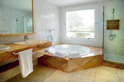 圣安东尼奥湾Villa Melody的带浴缸、水槽和窗户的浴室