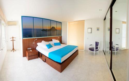 圣安东尼奥湾Villa Melody的一间卧室设有一张大床和玻璃墙