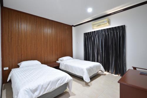 碧差汶AT TP HOTEL的酒店客房设有两张床和窗户。