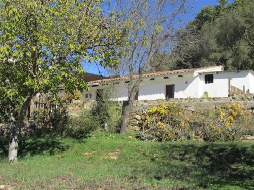科尔特斯德拉夫龙特拉Casita la Luna Rosa的白色的房子,有石墙和树木