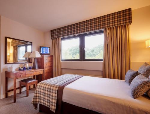 斯特灵斯特灵力推酒店的配有一张床、一张书桌和一扇窗户的酒店客房