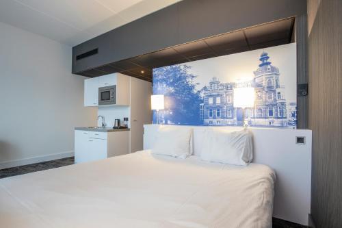 奥斯Fletcher Hotel-Restaurant Oss的卧室配有一张白色大床,墙上挂有绘画作品
