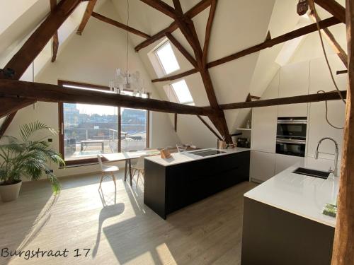 根特Burgstraat 17 Apartment in Exclusive Patrician House in Medieval Ghent的大型厨房设有木制天花板和大窗户