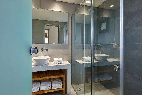 锡西卡斯特罗村度假酒店的一间带两个水槽和玻璃淋浴间的浴室