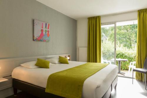 普罗梅尔Hôtel du Golf Saint-Laurent的一间卧室设有一张大床和一个窗户。