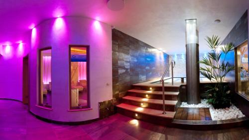 阿莱盖拉麦伊森健康温泉酒店的一间紫色照明的房间,大楼内的楼梯