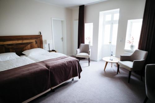 BassumZum Mühlenteich的一间卧室配有一张床、两把椅子和一张桌子