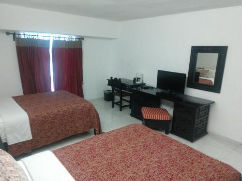 比亚埃尔莫萨Hotel Maya Tabasco的酒店客房设有两张床、一张桌子和一面镜子