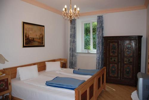 克洛斯特新堡Villa Kreuthhof Appartements的卧室配有带蓝色枕头的大型白色床