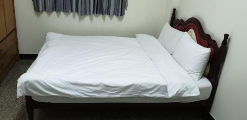 嘉义市兰州四街86号的一张带白色床单和枕头的床