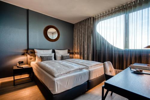斯图加特CLOUD No7 APARTMENTS的酒店客房设有一张大床和一张桌子。