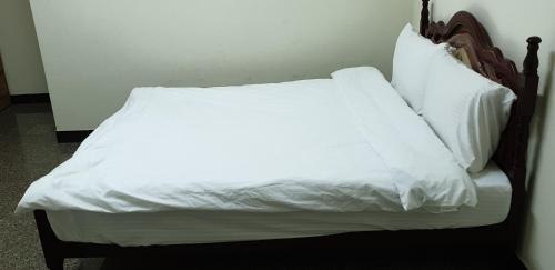 嘉义市兰州四街86号的一张带白色床单和枕头的床