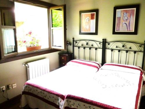 利亚内斯Las endrinas的卧室配有白色的床和2扇窗户。