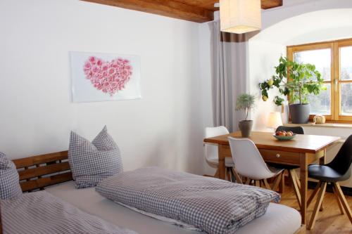 罗滕布Ultra Alpes Luitpold的一间卧室配有一张床和一张桌子及椅子
