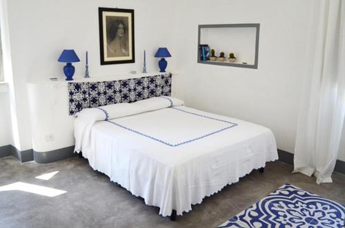 吉诺萨滨海马塞里亚蒙特多罗农家乐的白色卧室配有一张带镜子的床