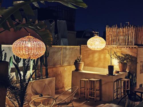 马拉喀什Riad Bamboo Suites & Spa的天井配有桌椅和灯
