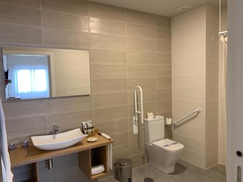 塞拉诺瓦Hotel Celanova的一间带卫生间、水槽和镜子的浴室