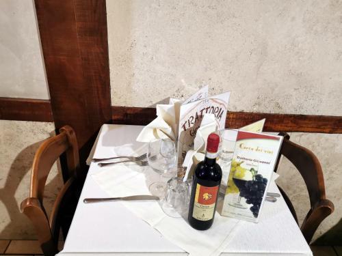 罗马华伦天奴宫酒店 的一张带一瓶葡萄酒和眼镜的白色桌子