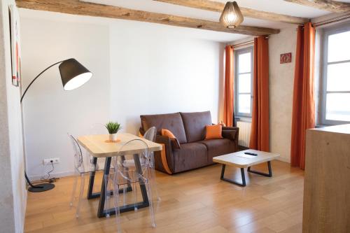 图尔尼Appartement A-Mi-Chemin - Centre-ville de Tournus的客厅配有沙发和桌子