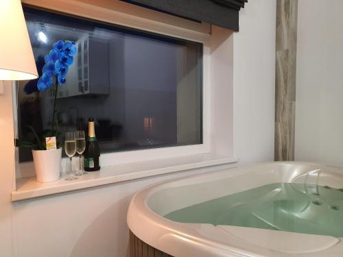帕内韦日斯Apartamentai su Jacuzzi的带浴缸的浴室和窗户