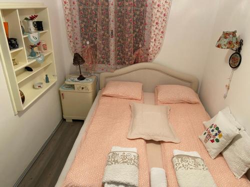 维尔蒂尼克波洛夫诺西公寓的一间小卧室,配有一张带粉红色床单的床