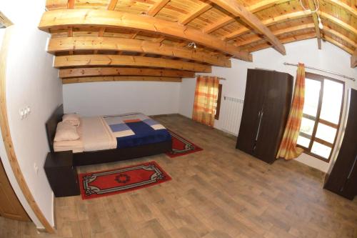 伊夫兰Villa SALAM的一间设有一张床铺的卧室,位于一个拥有木制天花板的房间