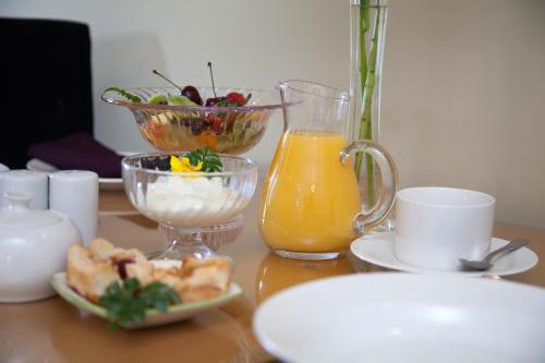 哈韦拉Tairoa Lodge的一张桌子,上面放着一碗水果和一壶橙汁