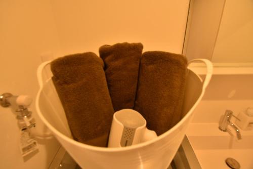 福冈ENZO / Vacation STAY 11623的浴室里一篮子里一束棕色毛巾