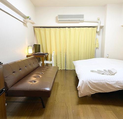 广岛La Foret Fujimi的带沙发、床和书桌的客房