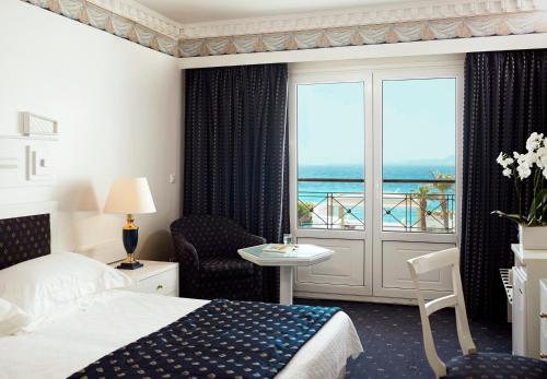 罗德镇Mitsis Grand Hotel的酒店客房设有一张床,享有海景。