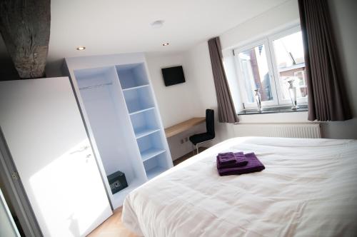 马塞克德玛萨查特公寓的卧室配有白色床和紫色毛巾