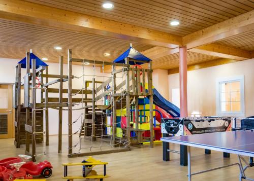 格雷丁Hotel Bayernhof的健身房设有带攀爬架和桌子的游戏室