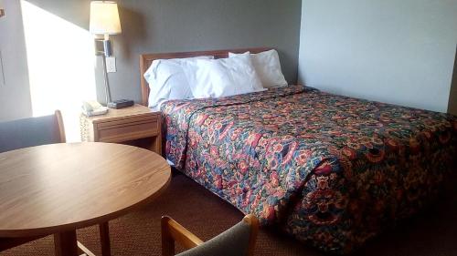 堪萨斯城KCI Lodge的酒店客房配有一张床铺和一张桌子。