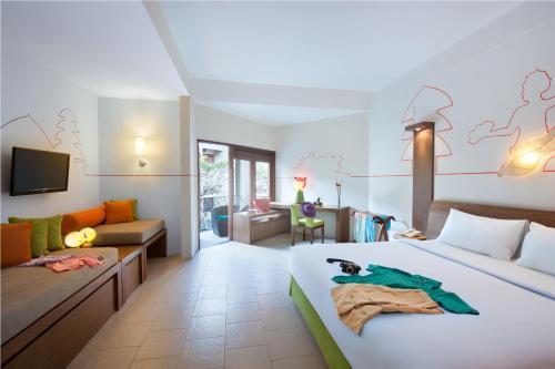 勒吉安ibis Styles Bali Legian的酒店客房,配有床和沙发