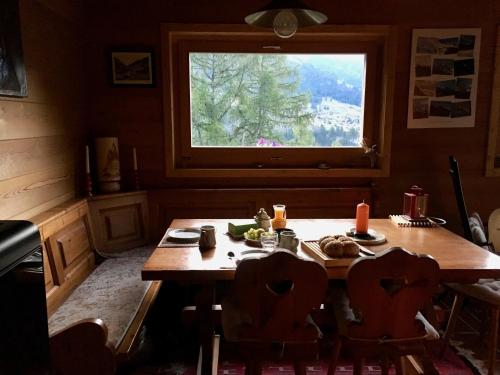 洪德莱斯Grand Pra的厨房配有木桌和窗户。