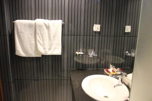 伊斯兰堡Hotel One Super, Islamabad的黑白浴室设有水槽和毛巾