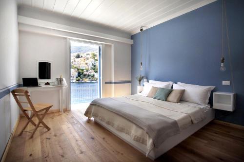 锡米Limani Life的蓝色的卧室设有床、书桌和窗户