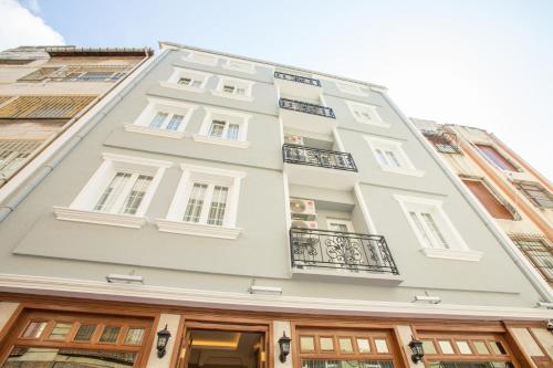 伊斯坦布尔Atlantis Royal Hotel的一座高大的白色建筑,设有窗户和阳台