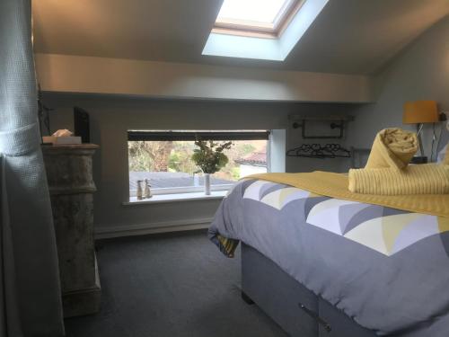 比代尔Aiskew Villa Annex的一间卧室配有一张带窗户的床和一张四柱床