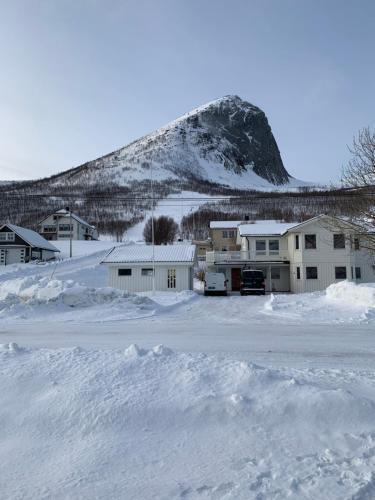 ToftaFjordgård B的一个有雪盖的停车场,后方是一座山