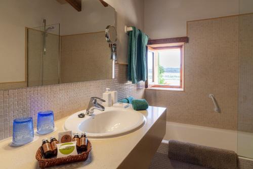 洛雷特-德维斯塔莱格罗塔帕勒姆农庄酒店的浴室配有盥洗盆、镜子和浴缸