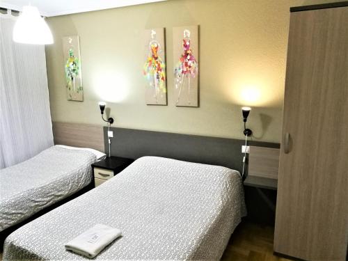 布尔戈斯圣地亚哥旅馆的酒店客房设有两张床和两盏灯。