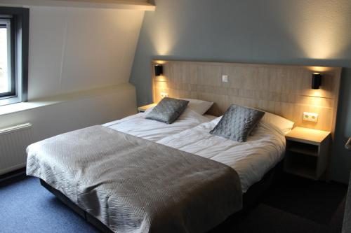比伦Hotel "De Klok"的一间卧室配有一张大床和两个枕头