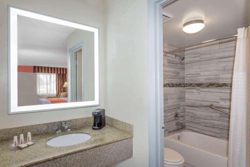维洛海滩维洛海滩豪生国际快捷酒店的浴室配有盥洗盆、卫生间和浴缸。